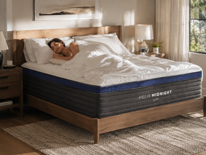 Helix Midnight Luxe hybrid mattress on a walnut bed frame in a warm bedroom setting
